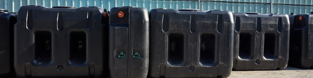Beerput kopen? Verschillende zwarte kunststof beerputten in diverse modellen en volumes opgesteld buiten bij de showroom in Wetteren